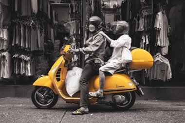 İki kişi sarı bisikletin üzerinde durdu.