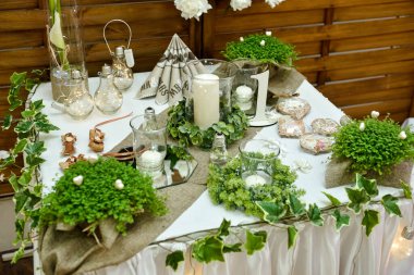 Doğal bitkilerle süslenmiş bir düğün masasının yakın çekimi.