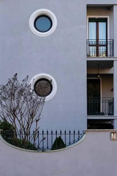 A vertical shot of a gray house with circle windows during the day