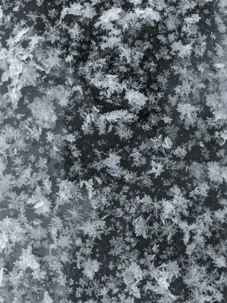 Een Verticaal Schot Van Grote Sneeuwvlokken Gevallen Een Ijzig Oppervlak — Stockfoto