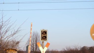 Gün batımında kırmızı ışıkta kapalı kat geçidi. Yavaş çekimde aşağı iniyoruz. Yol trafiği ve demiryolu altyapısı.