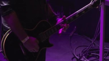Gitarını mor neon ışıklarla çalan bir gitarist Poppodium Volt, Sittard, Hollanda 'da canlı bir sette