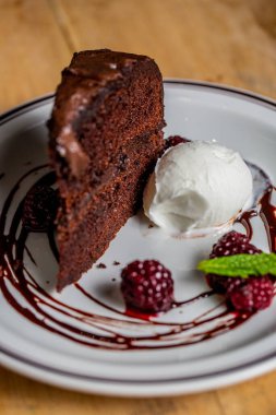 Vanilyalı dondurma ve böğürtlenli çikolatalı kekin yakın çekimi.