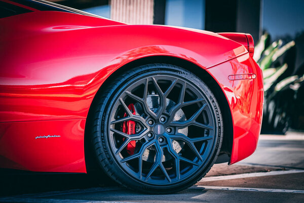 A close-up of a red Ferrari car rim wheel, side view