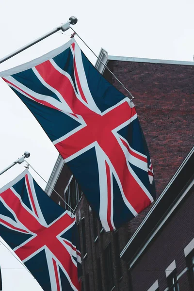 英国国旗与建筑物相连的两面英国国旗的垂直截图 — 图库照片
