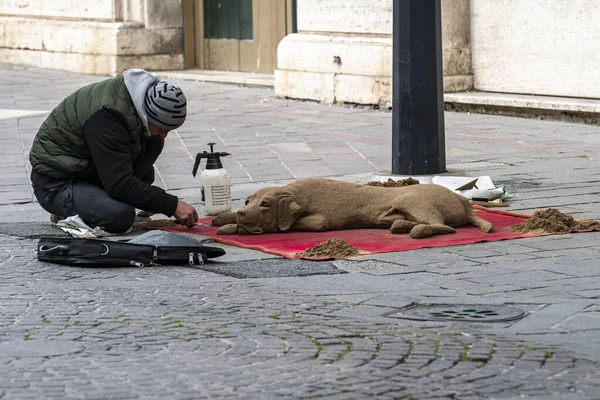 イタリアのテルニ通りにある犬の砂像を作っている男 — ストック写真