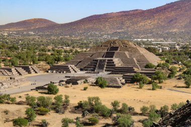 Teotihuacan, Meksika 'da Ay Piramidi' nin arka planda dağlarla çekilmiş bir fotoğrafı.