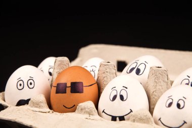 Siyah arka planda yüzü boyalı komik yumurtalar.