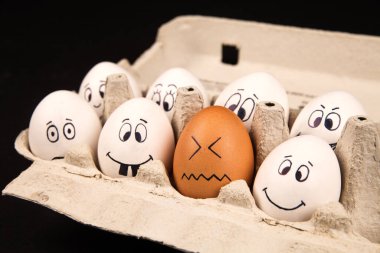 Siyah arka planda yüzü boyalı komik yumurtalar.