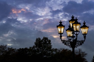 Arka planda renkli bulutlu gökyüzü olan antika siyah bir sokak lambasının güzel bir görüntüsü.