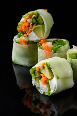 Geleneksel Asya Japon yemekleri. Taze suşi koyu ve siyah arkaplanda yuvarlanır