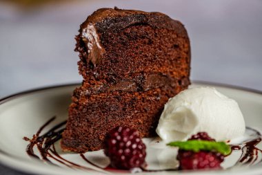 Vanilyalı dondurma ve böğürtlenli çikolatalı kekin yakın çekimi.