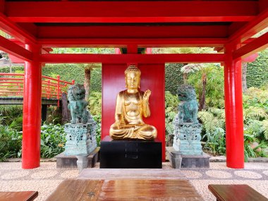 Buda 'nın altın heykeli kırmızı ahşap bir köşkün altında.