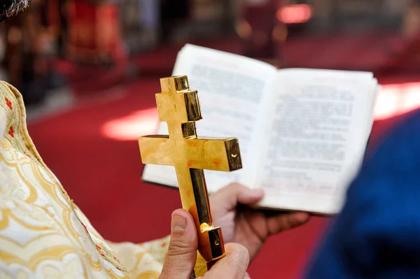 Zbliżenie Ręki Księdza Trzymającego Złoty Krzyż Nad Biblią Rozmytym Tle — Zdjęcie stockowe