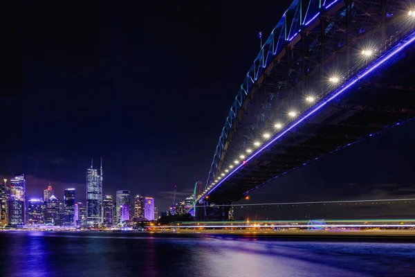 シドニーの街並み ニューサウスウェールズ州 オーストラリアにつながる紫色のライトアップされたハーバーブリッジの夜景 — ストック写真