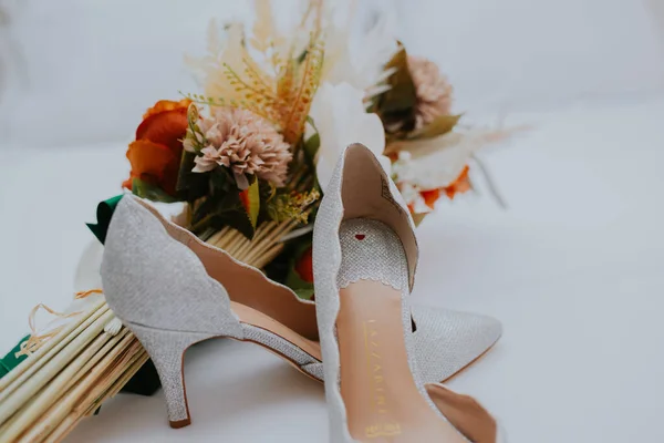 婚礼当天 一双新娘的鞋子和一束鲜花的特写 — 图库照片