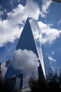 New York 'taki bulutlu gökyüzünü yansıtan bir Dünya Ticaret Merkezi gökdeleninin dikey görüntüsü.