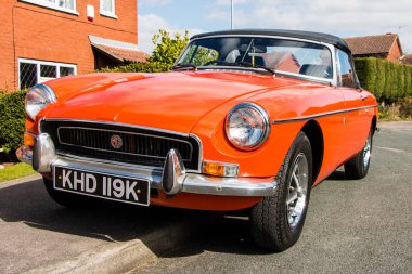 Klasik bir İngiliz arabası MG MGB kırsala park etmiş, iki kapılı spor araba..