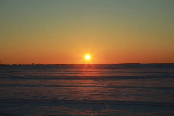 Piękny Widok Śnieżnego Pola Podczas Pomarańczowego Zachodu Słońca — Zdjęcie stockowe