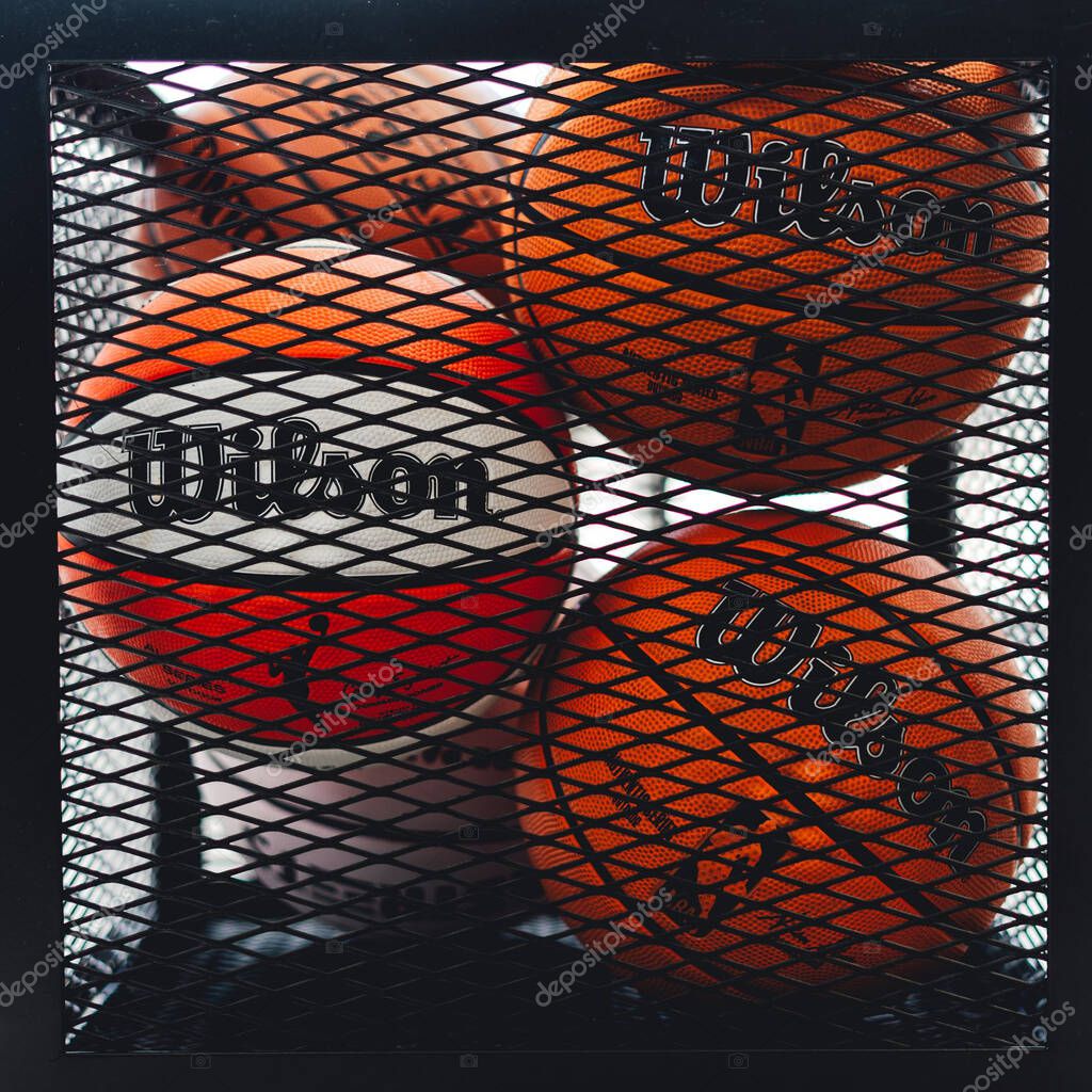 A stack of orange Wilson basketball balls behind the portable cage