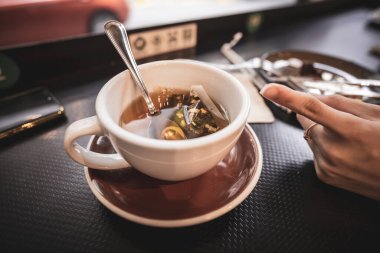 Bir bardak limonlu zencefilli nane çayına işaret eden bir parmak.