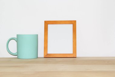 Fotokopi alanı olan ahşap bir çerçeve ve beyaz arka planda mavi bir kupa