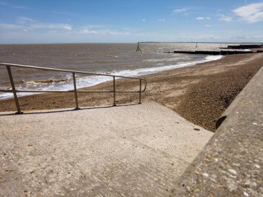 Beton tekne rampası çakıl taşı plajına gidiyor. Dovercourt, Harwich, Essex, İngiltere.