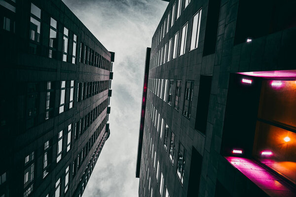 A low angle shot of modern black buildings against a cloudy sky in Montreal, Ontario, Canada