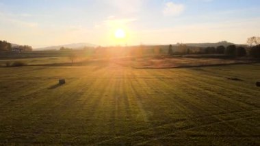 İnsansız hava aracı, gün batımında yeşil vadide uçuyor.