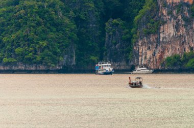 Koh Phi Phi Adası Körfezi, Koh Lanta, Tayland 'daki bir turist teknesinin uzak görüntüsü.
