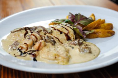 Beyaz tabakta servis edilen lezzetli bir restoran yemeği.