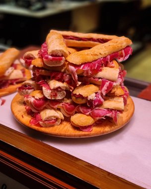 Dikey olarak taze lezzetli sandviçler ve masada domuz pastırması.