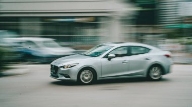 Yol boyunca ilerleyen gümüş bir arabanın çekimleri.