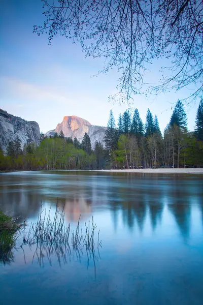 一个美丽的湖的垂直照片 背后有高山和树木 — 图库照片