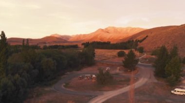 Tekapo Gölü yakınlarında parlayan dağlarla Sunset Kamp Alanı Yeni Zelanda, Güney Adası