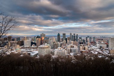 Bulutlu bir gökyüzünün altındaki şehir manzarası.