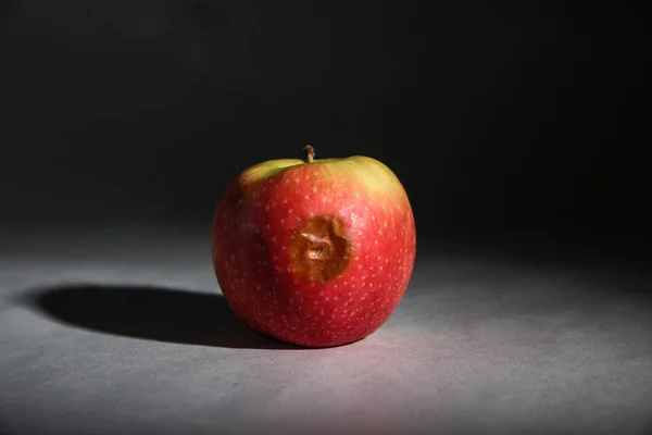 Ein Roter Apfel Mit Einem Faulen Fleck Auf Einer Grauen — Stockfoto