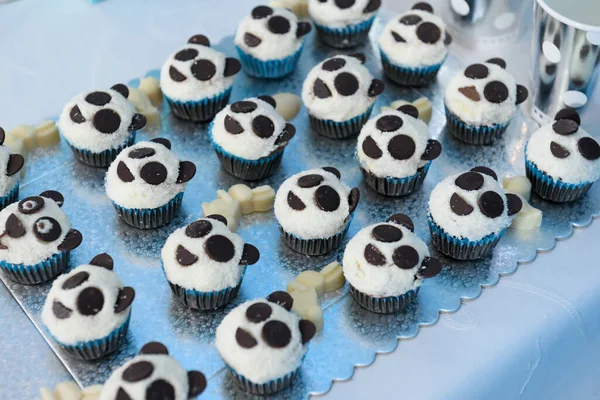 A closeup of black and white panda muffins on tray