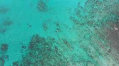 Bali 'de turkuaz suda şnorkelle yüzen bir dalgıcın çember fotoğrafı.
