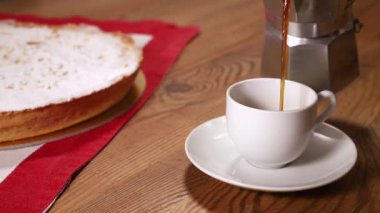 Kahveyi beyaz fincana koy, keki tahta masaya koy, mola ver.