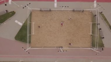 Sahada plaj voleybolu oynayan insanların hava görüntüsü.