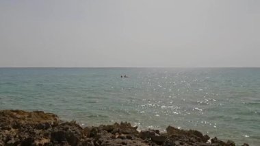 Eloro Sahili, Noto, Sicilya olarak da bilinen Cayman Sahili yakınlarındaki İyon denizinde kayak yapan insanlar.