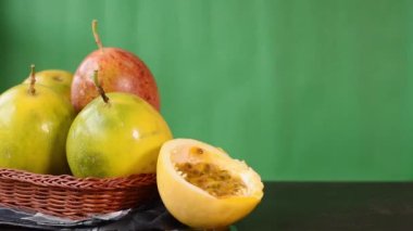 Bir kase tutku meyvesi ve bir bardak taze sıkılmış meyve suyu yanında dilimlenmiş tutku meyvesi.