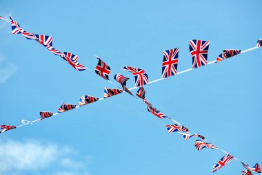 Büyük Britanya bayrağının alçak açısı mavi gökyüzü arkaplanından geçiyor.