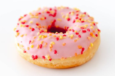 Beyaz arka planda izole edilmiş pembe bir çöreğin yakın plan çekimi.