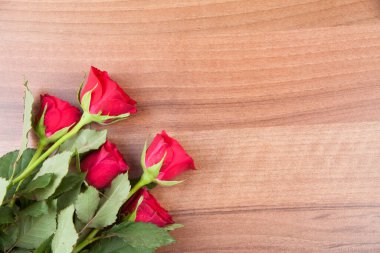 Red roses arranged on wooden surface
