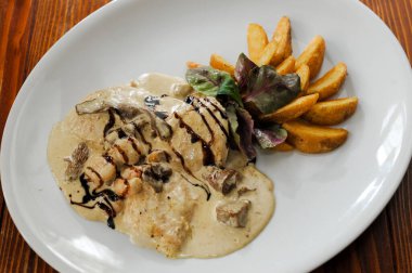 Beyaz tabakta servis edilen lezzetli bir restoran yemeği.