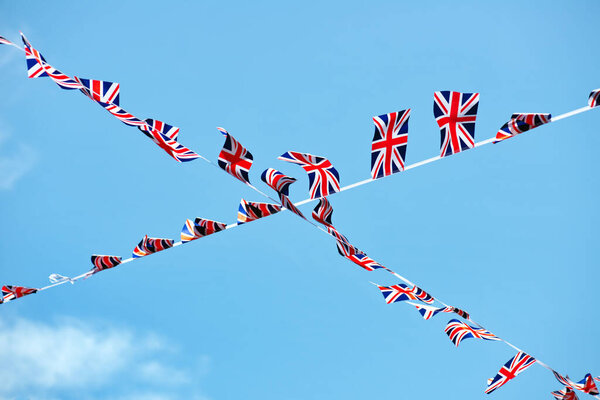 A low angle of the Great Britain flag bunting crossing on blue sky background