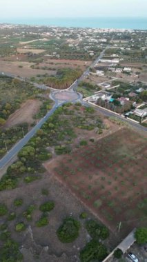 İtalya 'nın Bevagna kentindeki San Pietro' da arka planda deniz bulunan bir kavşağın dikey drone görüntüsü.