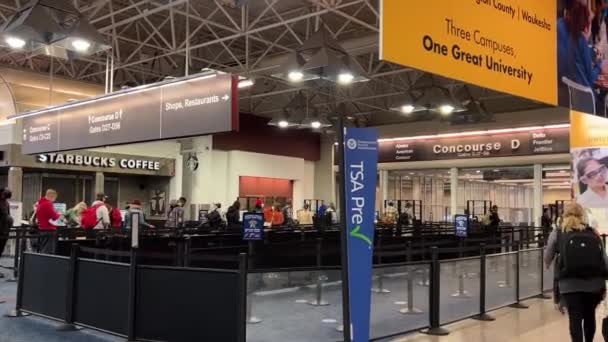 米国ミルウォーキーのミッチェル国際空港のTsaチェックポイントに並んでいる乗客の見解 — ストック動画